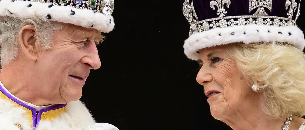 König Charles III. und Königin Camilla sehen sich an, als sie nach ihrer Krönung auf dem Balkon des Buckingham-Palastes stehen (Archivbild).