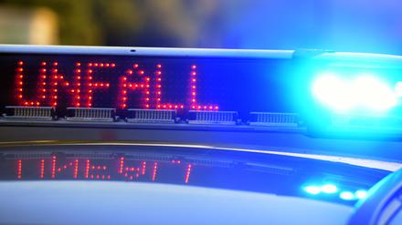 Auf einem Polizeifahrzeug warnt eine Leuchtschrift vor einer Unfallstelle. 