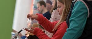 04.05.2024, Brandenburg, Potsdam: Ein Kind experimentiert mit einem gefüllten Glas beim Tag der Wissenschaft. Rund 35 Institute und Hochschulen aus Potsdam und Brandenburg präsentieren sich mit einem umfassenden Programm. Foto: Michael Bahlo/dpa - ACHTUNG: Nur zur redaktionellen Verwendung im Zusammenhang mit der aktuellen Berichterstattung über den Tag der Wissenschaften und nur mit vollständiger Nennung des vorstehenden Credits +++ dpa-Bildfunk +++