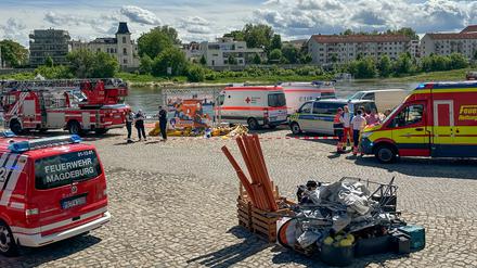 Einsatzfahrzeuge stehen am Elbufer. Die Hüpfburg soll in die Elbe geweht worden sein. Aktuell sei niemand mehr in Gefahr, sagte ein Sprecher der Polizei der Deutschen Presse-Agentur. Foto: -/dpa-Zentralbild/dpa +++ dpa-Bildfunk +++