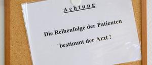 Ein Schild „Achtung. Die Reihenfolge der Patienten bestimmt der Arzt!“ hängt in einer Kinderarztpraxis im Wartezimmer.