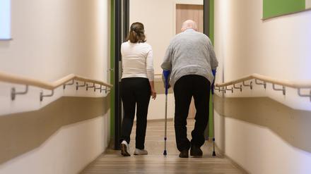 Ein Patient geht mit Krücken durch einen Flur.