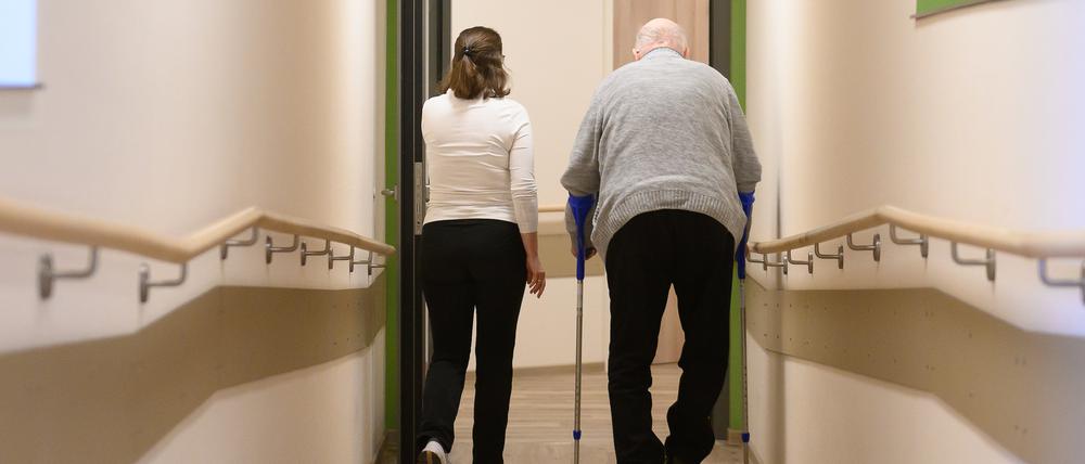 Ein Patient geht mit Krücken durch einen Flur.