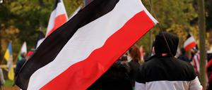 Ein Teilnehmer mit einer schwarz-weiß-roten Reichsflagge während einer Demonstration von Reichsbürgern und anderen Rechtsextremen.
