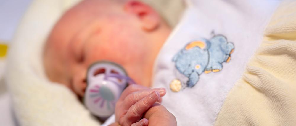 Eine Hebamme kümmert sich um einen Säugling.