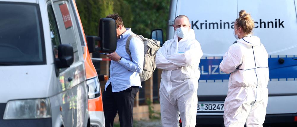 Kriminaltechniker und Gerichtsmediziner in weißen Schutzanzügen ermitteln am Tatort in Spandau.