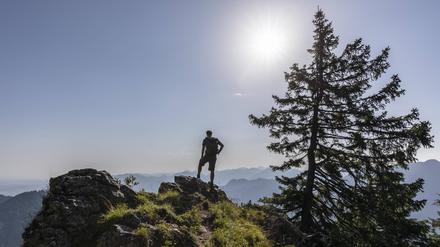 Ein Wanderer vor einem Bergpanorama in Bayern.