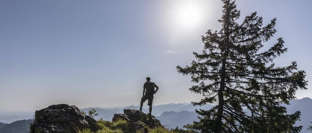 Ein Wanderer vor einem Bergpanorama in Bayern.