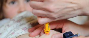 ARCHIVÂ - Ein MÃ¤dchen, das an Diabetes Typ 1 erkrankt ist, bekommt am 26.04.2011 in Berlin von ihrer Mutter mit einem Pen das notwendige Insulin gespritzt. Die Zuckerkrankheit trifft nicht nur Alte und Dicke. Immer mehr Kinder erkranken an Typ 1-Diabetes. Foto: Jens Kalaene/dpa (zu dpa Â«RÃ¤tsel um Diabetes 1 - immer mehr Kinder zuckerkrankÂ» vom 08.11.2013) +++ dpa-Bildfunk +++