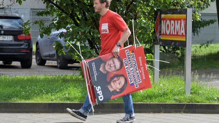 Im Einsatz für die Gesellschaft. Ein Freiwilliger hängt Wahlplakate auf. 