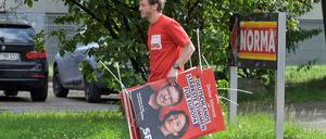 Im Einsatz für die Gesellschaft. Ein Freiwilliger hängt Wahlplakate auf. 