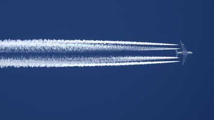 Ein Flugzeug der Qatar Airline hinterlässt am wolkenlosen Himmel Kondensstreifen.