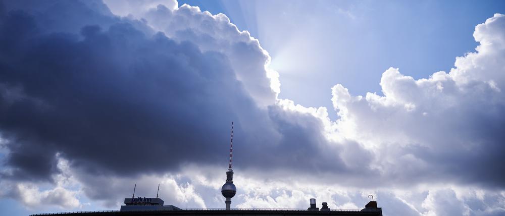 ARCHIV - 02.10.2022, Berlin: Die Sonnenstrahlen kommen hinter einer dunklen Wolke über dem Fernsehturm hervor. (zu dpa: «Wolken und Sonne am Wochenende in Berlin und Brandenburg») Foto: Annette Riedl/dpa +++ dpa-Bildfunk +++