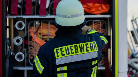 Ein Feuerwehrmann holt Equipment aus einem Einsatzfahrzeug.