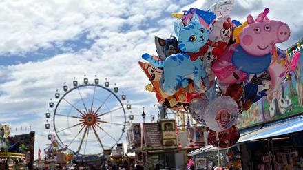 Besucher des Frühlingsfests gehen über die Theresienwiese in München. 