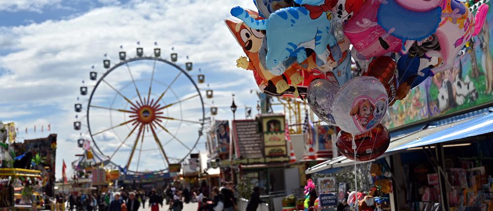Besucher des Frühlingsfests gehen über die Theresienwiese in München.