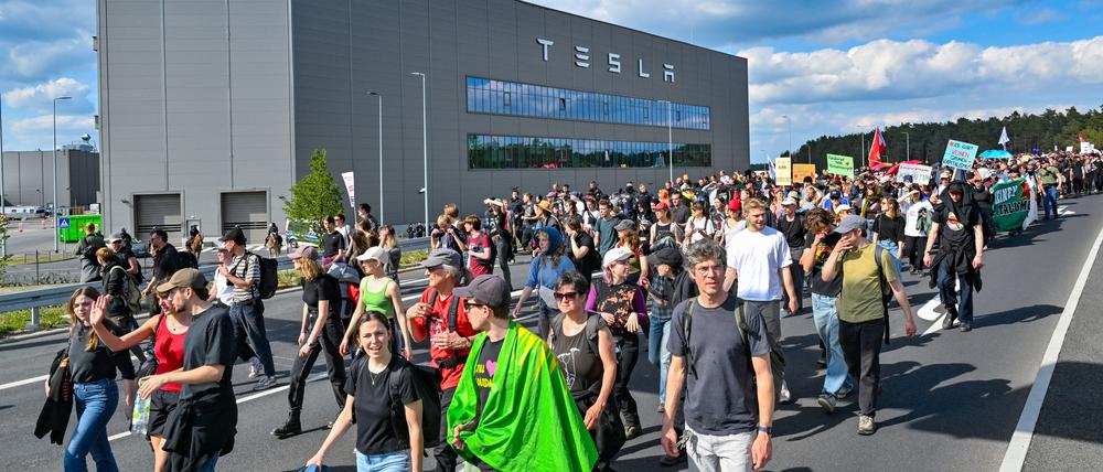11.05.2024, Brandenburg, Grünheide: Teilnehmer einer Protestveranstaltung gehen zum Werk von Tesla.