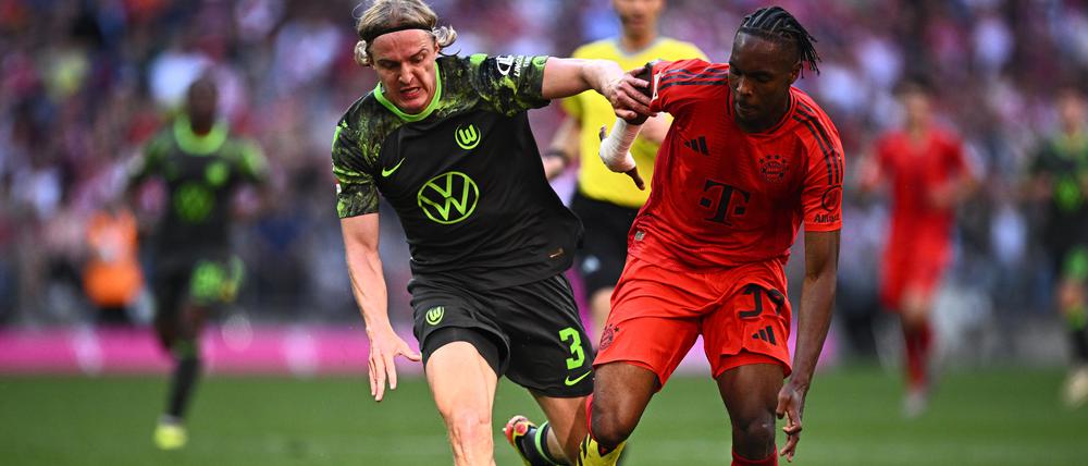 Wolfsburgs Sebastiaan Bornauw (l) und Münchens Mathys Tel kämpfen um den Ball. 