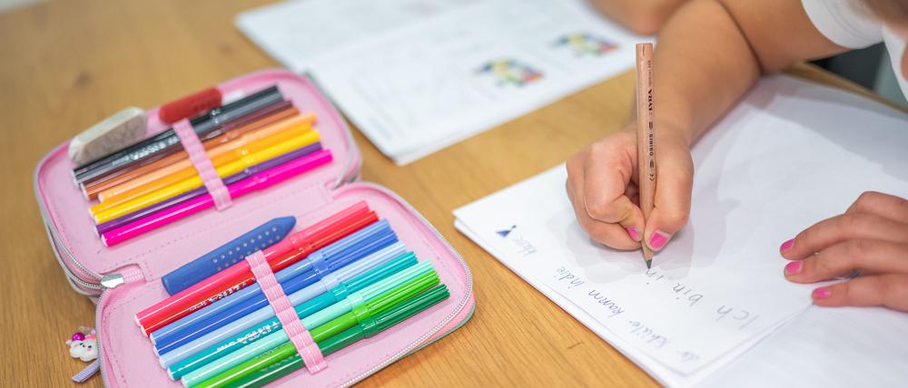 Schüler sitzen an einem Tisch und erledigen Schulaufgaben. (Symbolbild)