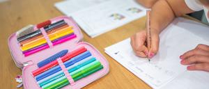 Schüler sitzen an einem Tisch und erledigen Schulaufgaben. (Symbolbild)