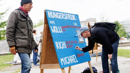 Der Klimaaktivist Wolfgang Metzeler-Kick (l) vom Bündnis «Hungern bis ihr ehrlich seid» malt steht neben der Tafel mit der Anzahl seiner Hungerstreik-Tage neben Adrian Lack (r) nach einer Pressekonferenz über den Gesundheitszustand der Klima-Hungerstreikenden.