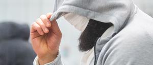 Abu Walaa, mutmaßlicher Anführer der Terrormiliz Islamischer Staat (IS) in Deutschland, steht im Oberlandesgericht Celle hinter einer Glasscheibe. 