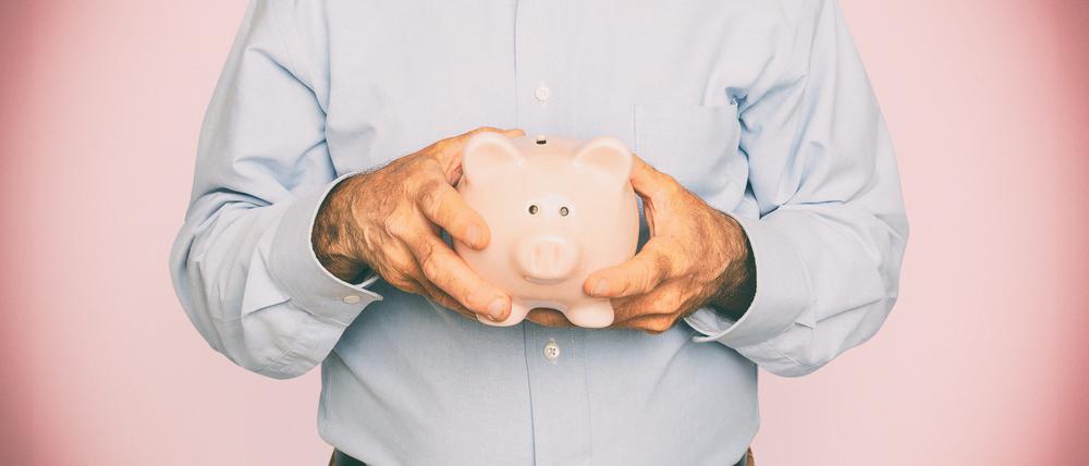 Senior man holding piggy bank for financial savings campaign