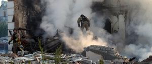 Ein Feuerwehrmann geht in Charkiw durch den Qualm eines Hauses, das nach russischem Beschuss in Flammen steht.  