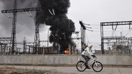 Ein Mann radelt nach einem russischen Angriff an einem Elektrizitätswerk in Charkiw vorbei. Durch einen der heftigsten Luftangriffe in mehr als zwei Jahren Angriffskrieg hat Russland in der Vorwoche schwere Schäden am Energiesystem der Ukraine angerichtet. In der ostukrainischen Großstadt Charkiw fiel der Strom komplett aus. 