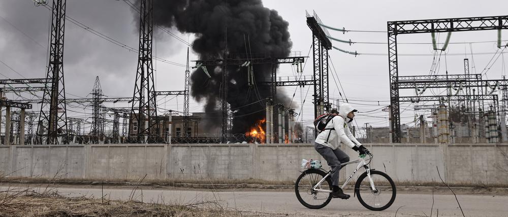 Ein Mann radelt nach einem russischen Angriff auf Charkiv an einem Elektrizitätswerk vorbei. (Archivbild)