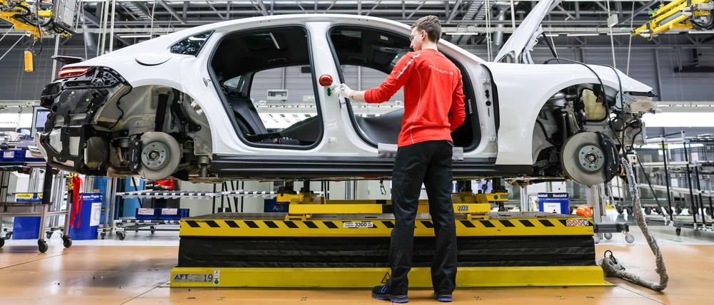 Ein Mitarbeiter montiert einen Porsche Panamera im Werk Leipzig.