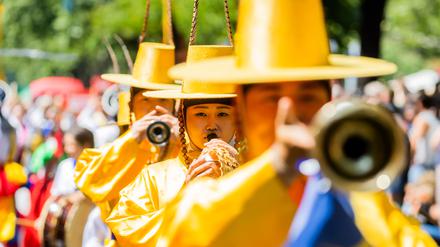 Darsteller einer koreanischen Gruppe treten beim Umzug des Karnevals der Kulturen in Berlin-Kreuzberg auf.