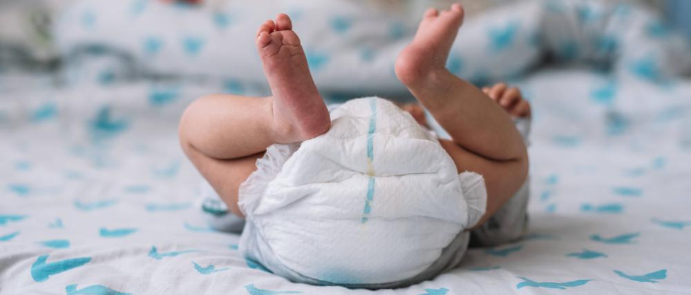 Ein Baby liegt mit Windel auf einem Wickeltisch (Symbolbild).