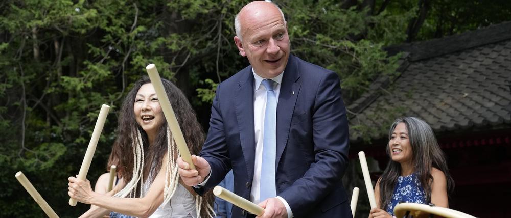 Kai Wegner, Regierender Bürgermeister von Berlin, versucht in der Residenz des deutschen Botschafters in Tokio die traditionelle japanische Trommel Taiko zu spielen.