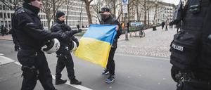 Bei einer pro-russischen Demo diskutiert ein Unterstützer der Ukraine mit Polizisten in Köln im April 2024.