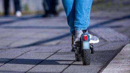 ARCHIV - 17.04.2024, Mecklenburg-Vorpommern, Wismar: Ein Reisender fährt mit seinem E-Scooter über den Bahnsteig. (zu dpa: «VGN verbietet E-Scooter in Bussen und Bahnen») Foto: Jens Büttner/dpa +++ dpa-Bildfunk +++