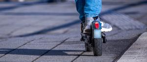 Ein Reisender fährt mit seinem E-Scooter über den Bahnsteig. 