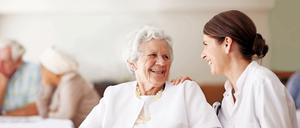 Eine Seniorin unterhält sich mit einer Pflegekraft.