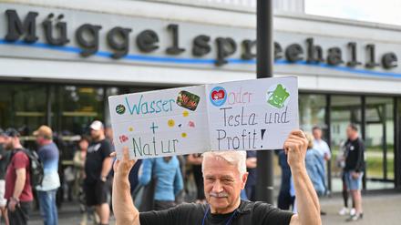 Ein Teilnehmer einer Bündnisinitiative protestiert vor der Müggelspreehalle.