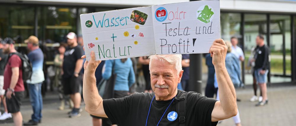 Ein Teilnehmer einer Bündnisinitiative protestiert vor der Müggelspreehalle.