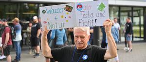 Ein Teilnehmer einer Bündnisinitiative protestiert vor der Müggelspreehalle.