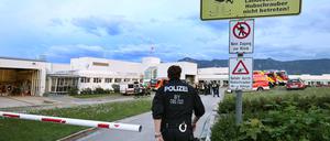 Polizisten und Einsatzkräfte der Feuerwehr stehen vor der abgeriegelten Notaufnahme des Unfallklinikums Murnau.