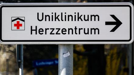 Ein Schild mit Richtungspfeil zum Uniklinikum Herzzentrum steht an einer Straße.