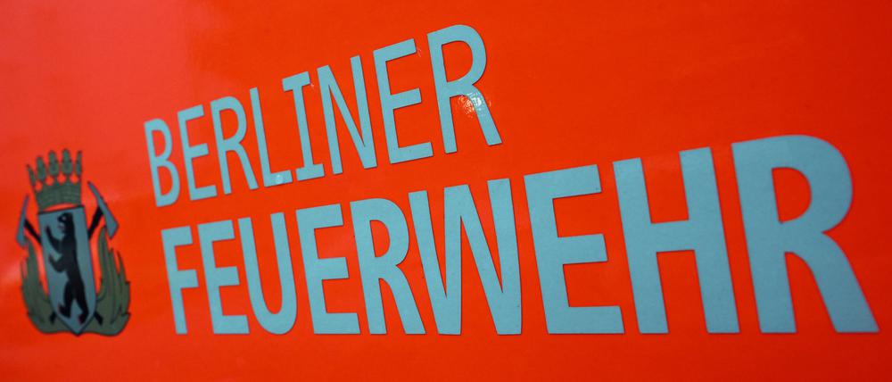 Der Schriftzug ·Berliner Feuerwehr· und das Wappen Berliner Feuerwehr mit dem Berliner Bären stehen auf der Tür eines Feuerwehrfahrzeuges. (Symbolbild)