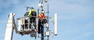 Fachkräfte bei Wartungsarbeiten an Telekommunikationsmast.