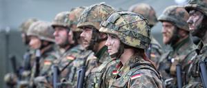 Eine deutsche Bundeswehrsoldatin steht zusammen mit Kameraden bei dem von der Bundeswehr angeführten Nato-Bataillon auf dem Militärstützpunkt in Rukla in Litauen.
