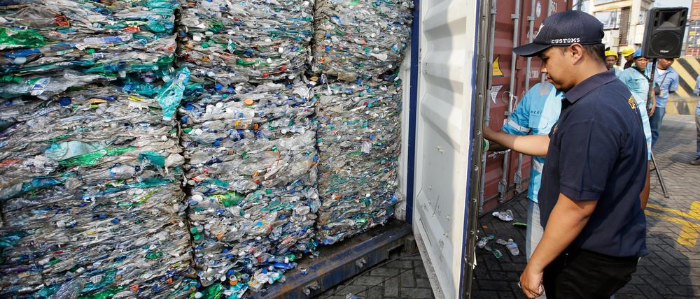 Ein Zollbeamter verschließt einen Container mit Plastikmüll am Hafen von Tanjung Priok.