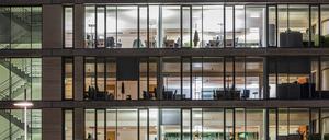 Glasfassade eines hell erleuchtetem Bürogebäudes 