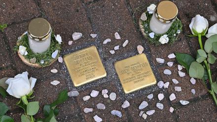 ARCHIV - 04.10.2023, Brandenburg, Spremberg: Weiße Rosen liegen neben neu verlegten Stolpersteinen zur Erinnerung an Nathan Bernfeld (1872-1950) und seine Frau Ellen Bernfeld (1898-1955). Initiiert wurde die Verlegung der Stolpersteine von der AG Spurensuche, die das Leben jüdischer Menschen in Spremberg sowie von Menschen, die aktiv im Widerstand gegen den Nationalsozialismus kämpften, erforscht. (zu dpa: «Erster Stolpersteinlauf in Potsdam - «Gegen das Vergessen»») Foto: Patrick Pleul/dpa +++ dpa-Bildfunk +++