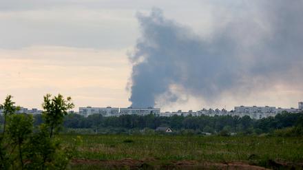 Nach dem Beschuss durch russische Truppen steigt eine Rauchsäule hinter Wohnhäusern auf. 